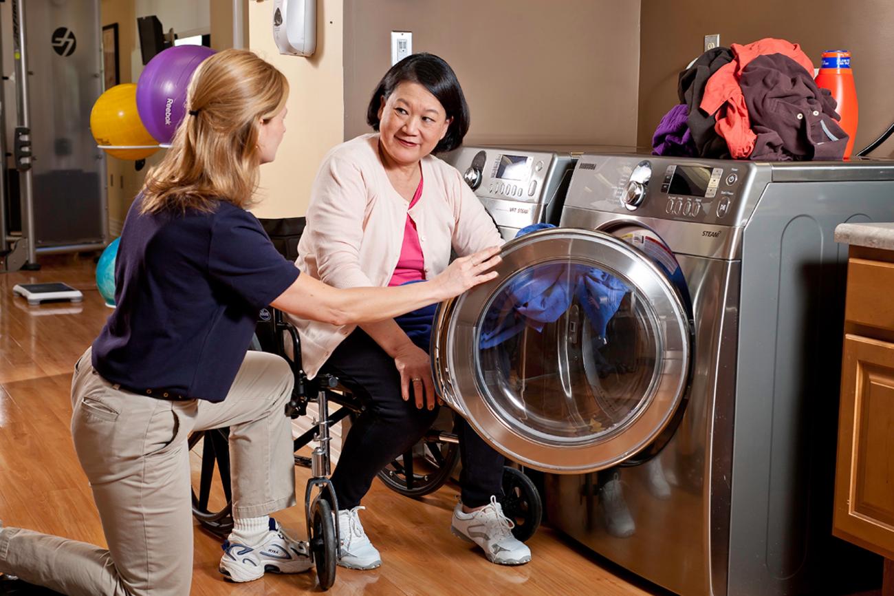 Occupational Therapist helping patient load a washing machine
