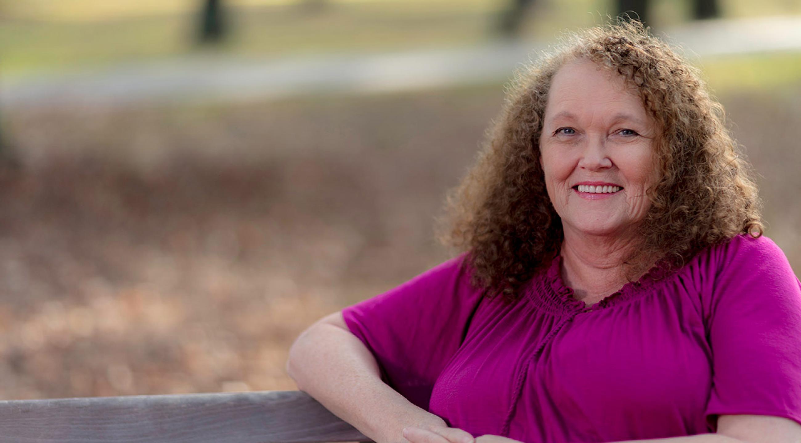 Lynda sitting on a bench